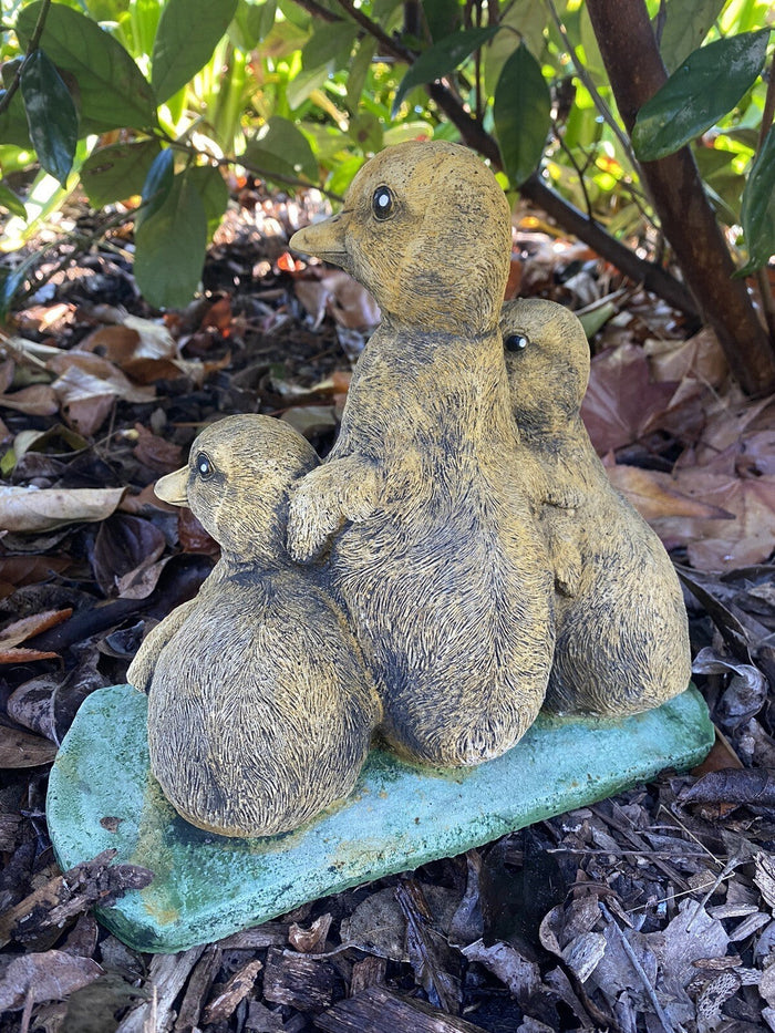 22nice4me Garden Statues set of three hand-painted concrete ducklings with a textured matt finish in a garden setting