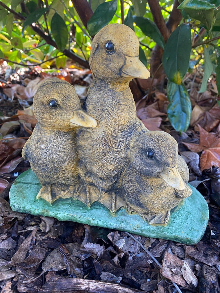 22nice4me Garden Statues set of three hand-painted concrete ducklings with a matte finish in a garden setting